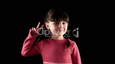 girl shows the Peace on black background