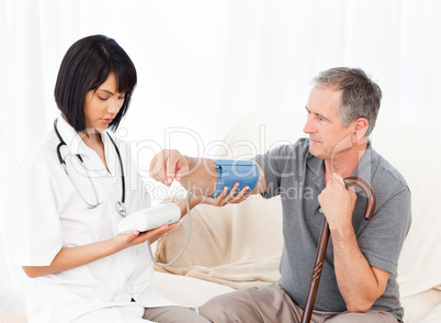 Nurse taking blood pressure of her patient