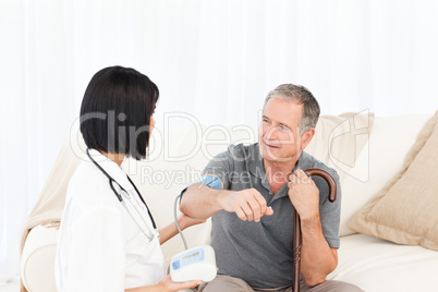 Nurse taking blood pressure of her patient