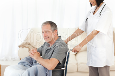 Man in his wheelchair with his nurse at home