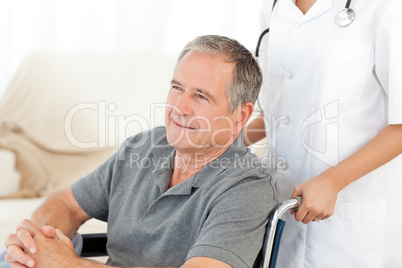 Man in his wheelchair with his nurse at home