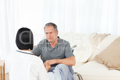 Man in his wheelchair with his nurse at home