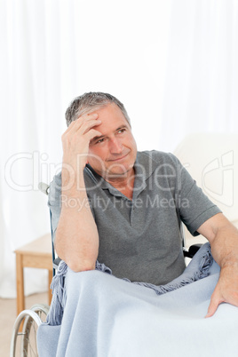 Senior in his wheelchair having a headache