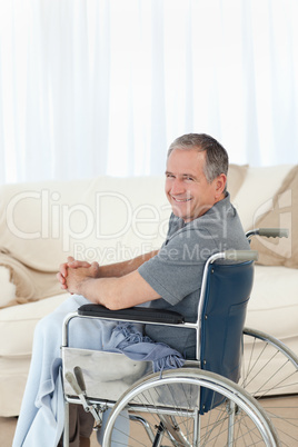 Mature man in his wheelchair looking at the camera