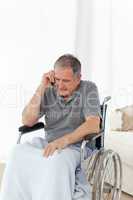 Senior in his wheelchair phoning