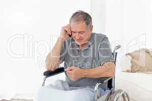 Senior in his wheelchair phoning