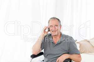 Senior in his wheelchair phoning