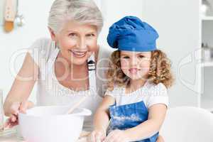 A little girl with her grandmother looking at the camera