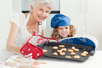 A little girl with her grandmother looking at the camera