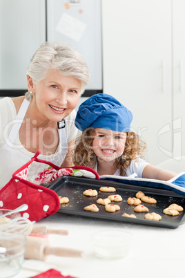 A little girl with her grandmother looking at the camera