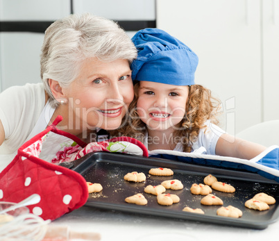 A little girl with her grandmother looking at the camera