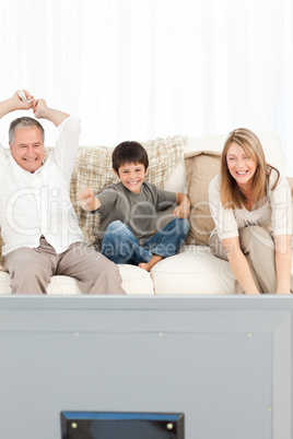 A little boy with his grandparents  in the living room