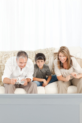 A little boy with his grandparents  in the living room