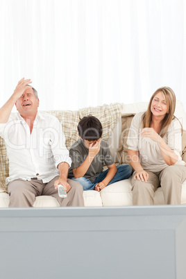 A little boy with his grandparents  in the living room