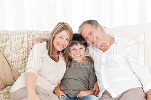 A little boy with his grandparents looking at the camera