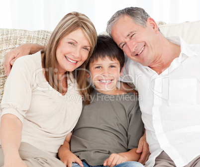 A little boy with his grandparents looking at the camera