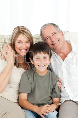 A little boy with his grandparents looking at the camera