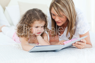 Young girl reading a book with her grandmother