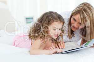 Young girl reading a book with her grandmother