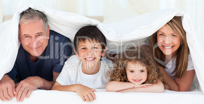 Family in their bedroom looking at the camera at home