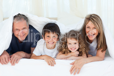 Family in their bedroom looking at the camera at home