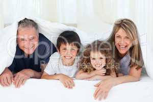 Family in their bedroom looking at the camera at home