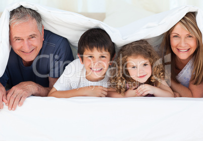 Family in their bedroom looking at the camera at home