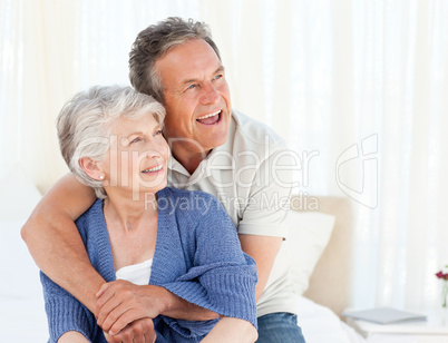 Senior couple hugging on their bed