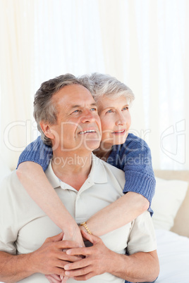 Senior couple hugging on their bed