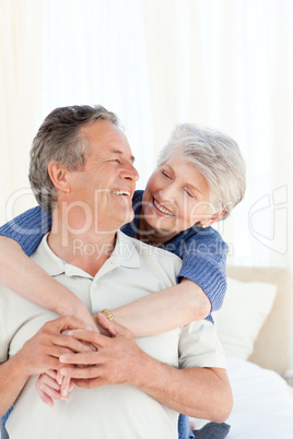 Senior couple hugging on their bed