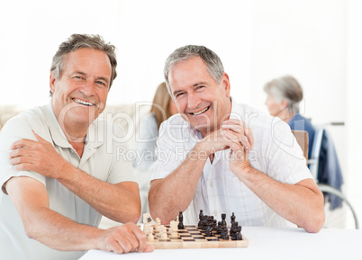 Men playing chess while their wifes are talking