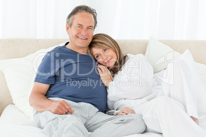 Senior couple lying down on their bed