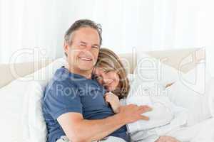 Senior couple lying down on their bed