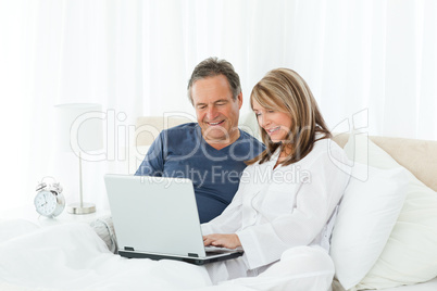 Mature lovers looking at their laptop