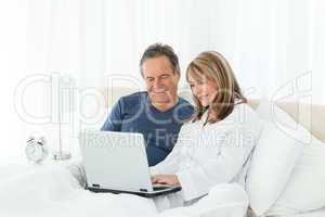 Mature lovers looking at their laptop
