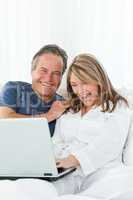 Mature lovers looking at their laptop