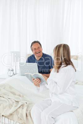 Retired couple talking together on their bed