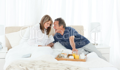 Lovely couple having breakfast in their bed