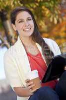 Happy Young Woman Drinking Coffee and Using Tablet Computer