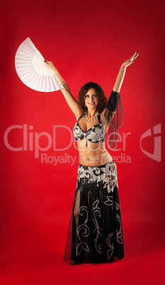 Woman in black arabian costume dance with fan