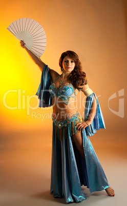 Mature woman in belly dance with fan