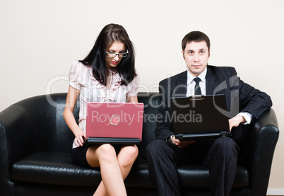 Businessmen with computers on sofa