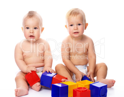 Two children play with building bricks