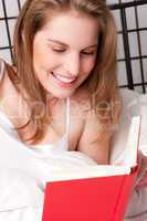 Frau mit Buch im Bett