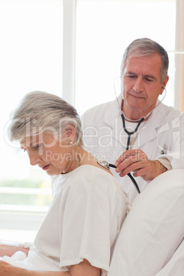 Senior doctor taking the heartbeat of his patient