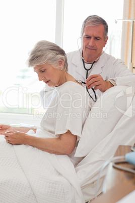 Senior doctor taking the heartbeat of his patient