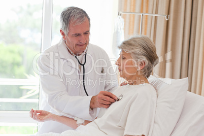 Senior doctor taking the heartbeat of his patient