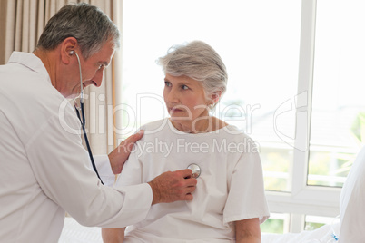 Senior doctor taking the heartbeat of his patient