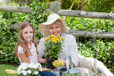 Grandmother with her granddaughter working in the garden