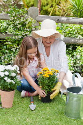 Grandmother with her granddaughter working in the garden